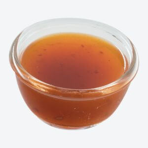 A small glass bowl filled with the Asian Spicy Sauce