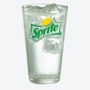 A glass of sprite  with ice cubes floating in it